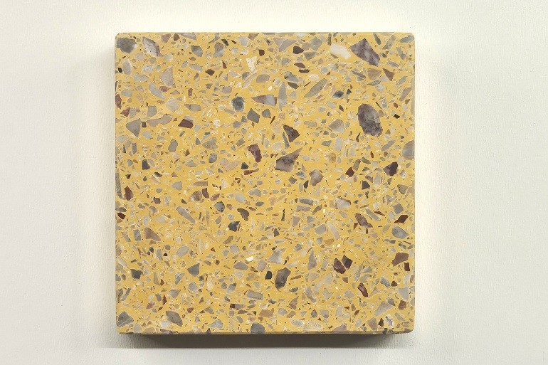 Geel terrazzo met Arabescato marmer, met lichte natuursteenfragmenten in een warme gele basis.