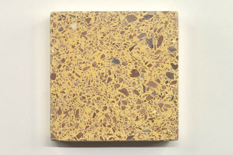 Geel terrazzo met bruin Mogano natuursteen, met warme bruintinten in een gele basis.