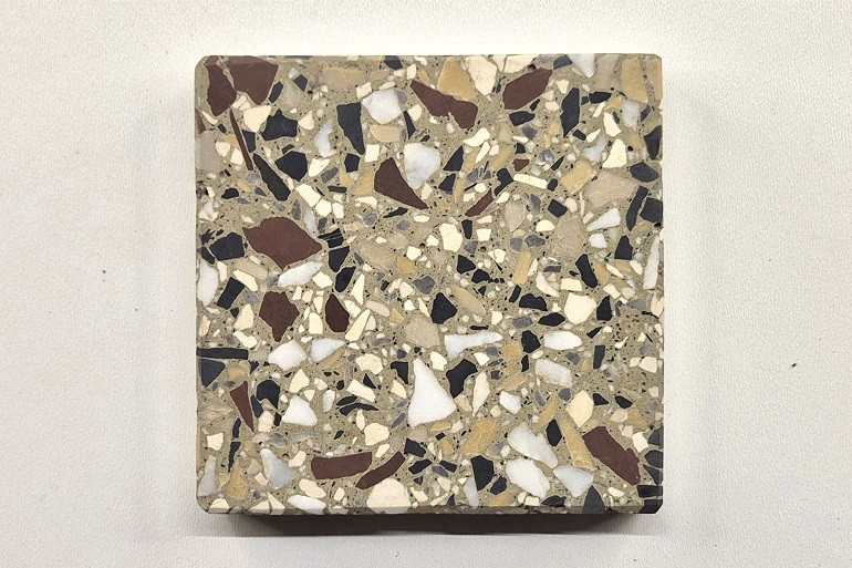 Geel terrazzo met Duits rood, Carrara marmer en Ulmer wit, met opvallende donkere en lichte steenfragmenten.