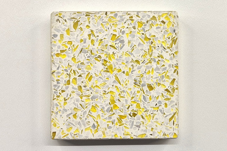 Geel terrazzo met geel glas en Carrara marmer, met lichte steenfragmenten en subtiele glaseffecten.