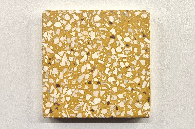 Geel terrazzo met Ulmer wit, met een warme gele basis en een gelijkmatige verdeling van lichte natuursteenfragmenten.