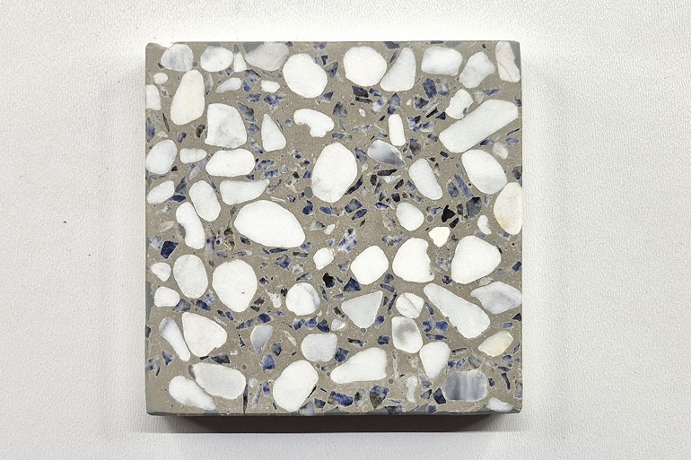 Grijs terrazzo met wit Carrara marmer en Bahia blauw graniet, met een opvallend contrast tussen lichte en donkere steensoorten.