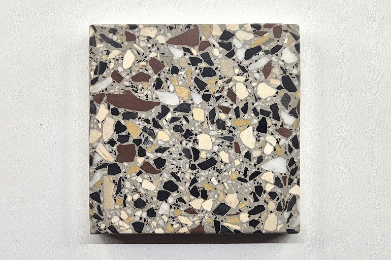 Grijs terrazzo met Carrara, Ulmer wit, Nero en Duits rood, een gevarieerde samenstelling van lichte, zwarte en donkerrode natuursteenfragmenten.