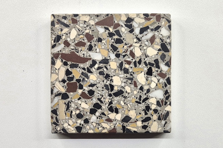 Grijs terrazzo met Carrara, Ulmer wit, Nero en Duits rood, een gevarieerde samenstelling van lichte, zwarte en donkerrode natuursteenfragmenten.