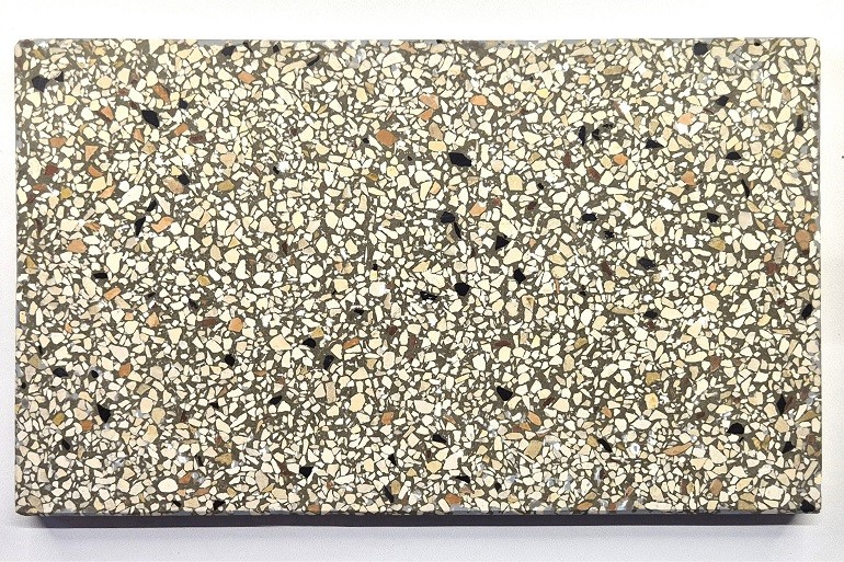 Grijs terrazzo met Ulmer wit, Nero en Verona rood, met een afwisselende structuur van lichte, zwarte en roodachtige natuursteenkorrels.