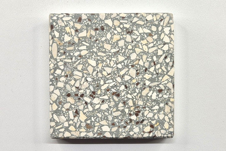 Grijs terrazzo met Ulmer wit en Rosso Levanto, met lichte natuursteenkorrels en subtiele donkerrode accenten.