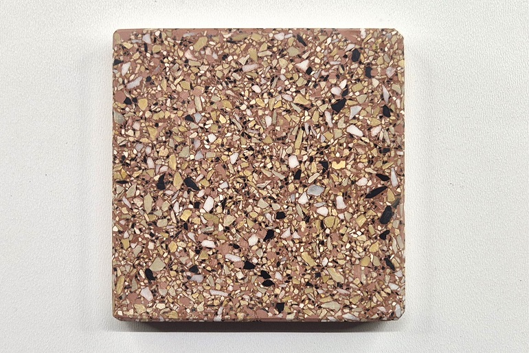 Rood terrazzo met geel Mori, Carrara marmer en Nero, met een levendige structuur van gele, witte en zwarte natuursteenkorrels.