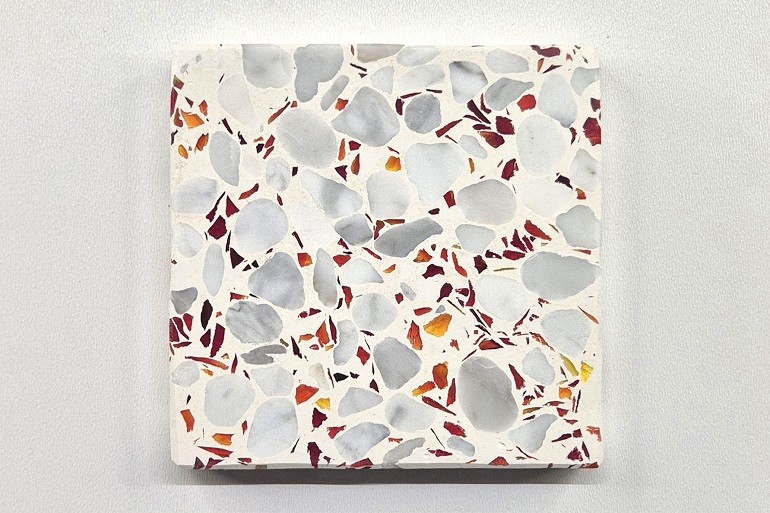 Licht terrazzo met rood glas en Carrara marmer, met opvallende rode glasfragmenten tussen de witte natuursteenkorrels.