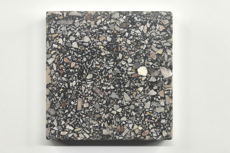 Zwart terrazzo met Arabescato marmer, met een levendig contrast tussen de donkere basis en de lichtgrijze natuursteenfragmenten.