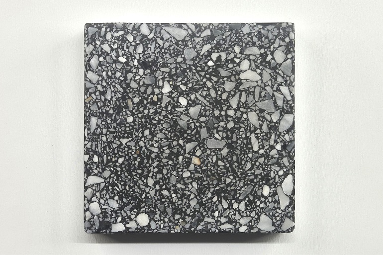 Zwart terrazzo met Bardiglio marmer, met een gemêleerde structuur van donkere en grijze natuursteenfragmenten.