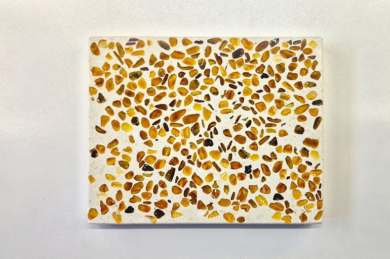 Handgemaakt wit terrazzo met kleine natuurlijke stukjes lichte barnsteen in geel tot honingkleurige en cognackleurige tinten.