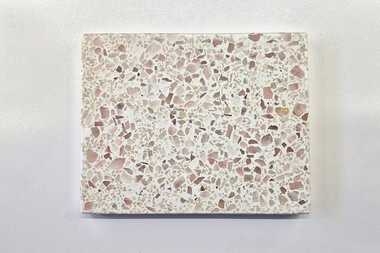 Terrazzo met natuurlijke roze calcietkristallen en een lichte basis.