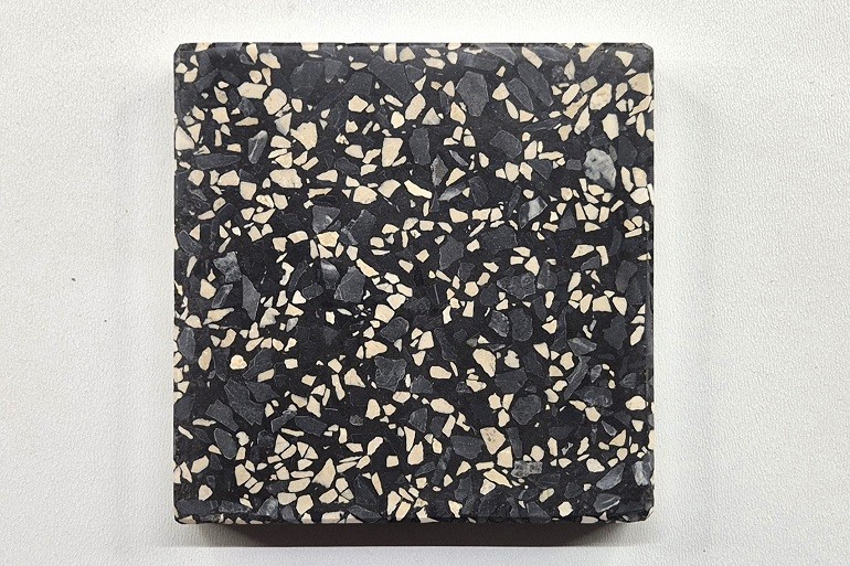 Zwart terrazzo met Ulmer wit en Sint-Anna grijs, met lichte en grijze natuursteenfragmenten die een levendig contrast vormen met de zwarte basis.